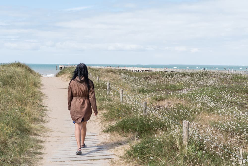 Femme qui marche vers la plage de Saint-Jean-de-Monts - Camping les Jardins de l'Atlantique